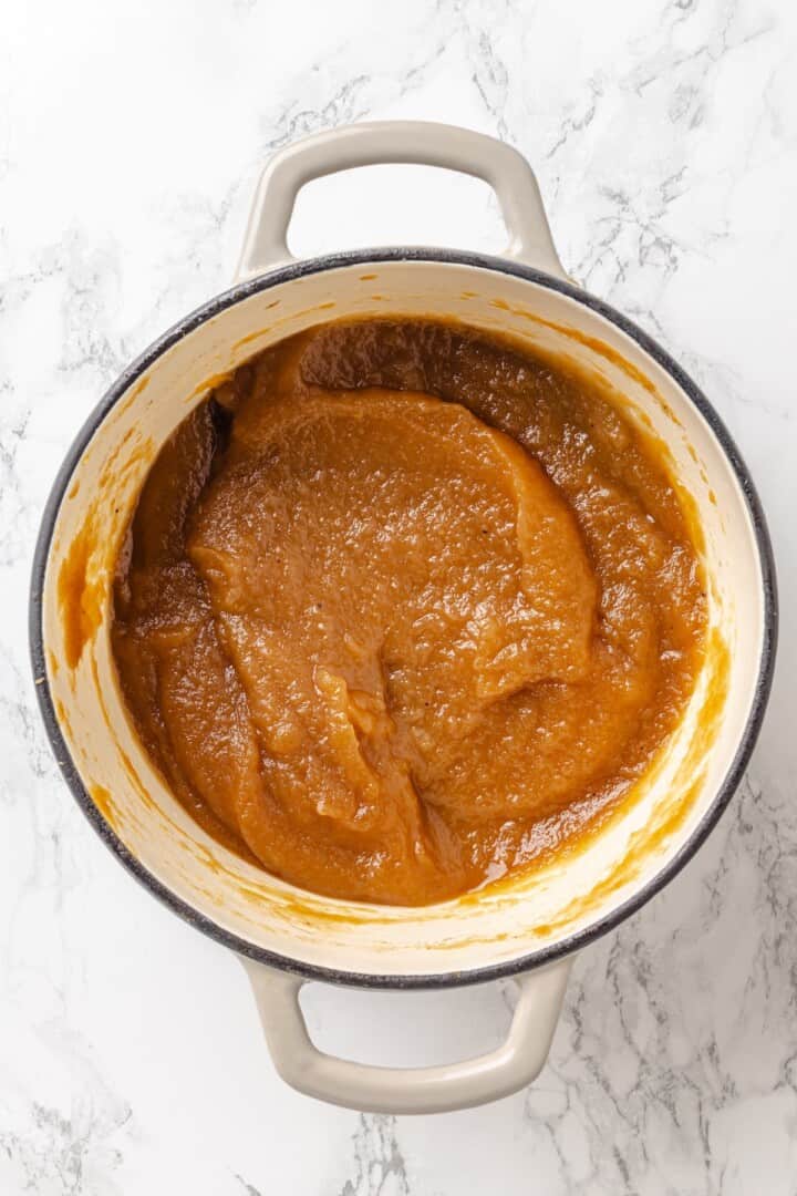 Apple butter should be the first on your autumn to-make list. Smooth and glossy, it's bursting with all the cozy spices of the season. Thickened apple butter in a Dutch oven, ready to transfer to jars.