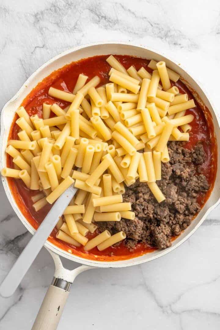 Vegan baked ziti, with its al dente noodles, savoury marinara sauce, and gooey cheese, married together bite after bite, is true comfort food. Folding cooked ziti and vegan ground meat alternative into marinara sauce.
