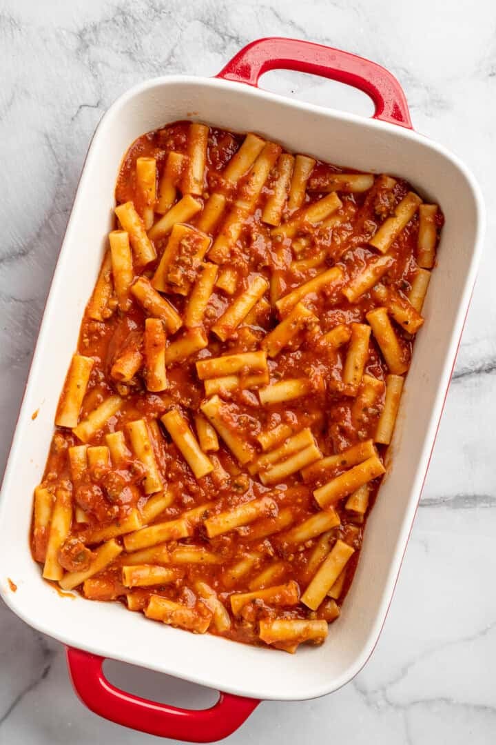 Vegan baked ziti, with its al dente noodles, savoury marinara sauce, and gooey cheese, married together bite after bite, is true comfort food. A mixture of cooked ziti, vegan ground meat alternative, and marinara sauce spread into a baking dish.