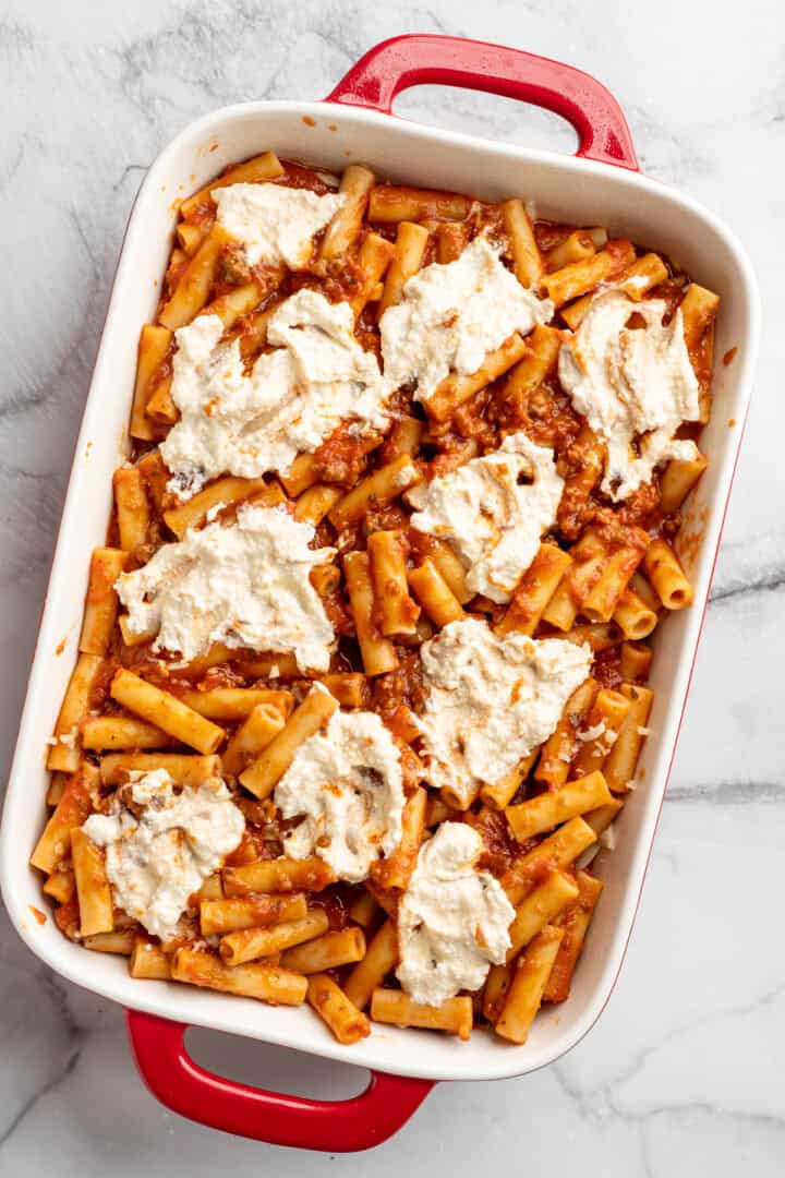Vegan baked ziti, with its al dente noodles, savoury marinara sauce, and gooey cheese, married together bite after bite, is true comfort food. Adding dollops of vegan ricotta to the second layer of saucy ziti (for baked ziti).