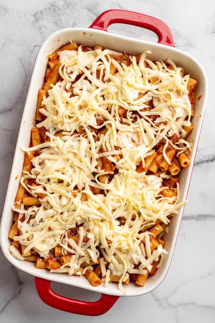 Vegan baked ziti, with its al dente noodles, savoury marinara sauce, and gooey cheese, married together bite after bite, is true comfort food. Adding a final layer of shredded vegan mozzarella to un-cooked baked ziti.