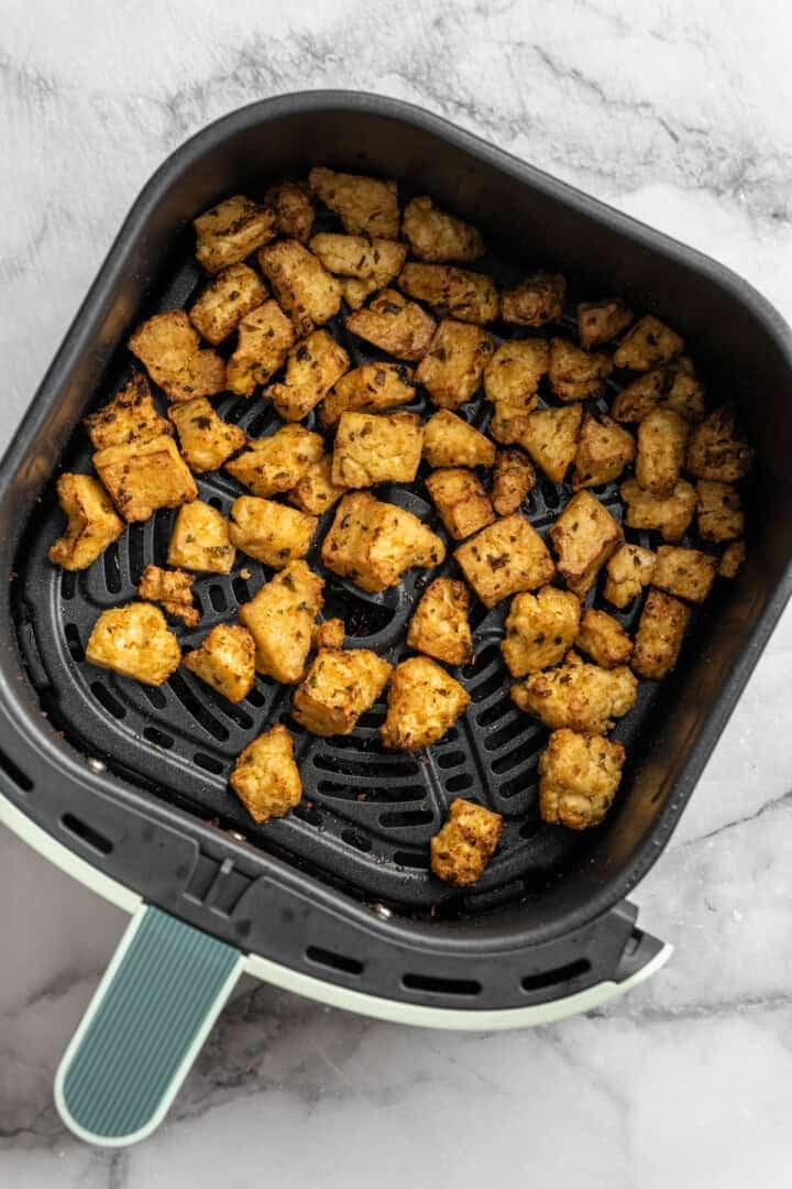 Bursting with zippy lime, sweet, citrusy cilantro, and a hit of garlic, this golden-brown cilantro lime marinated tofu is perfect for tacos. Golden brown cilantro lime marinaded tofu spread in an air fryer.
