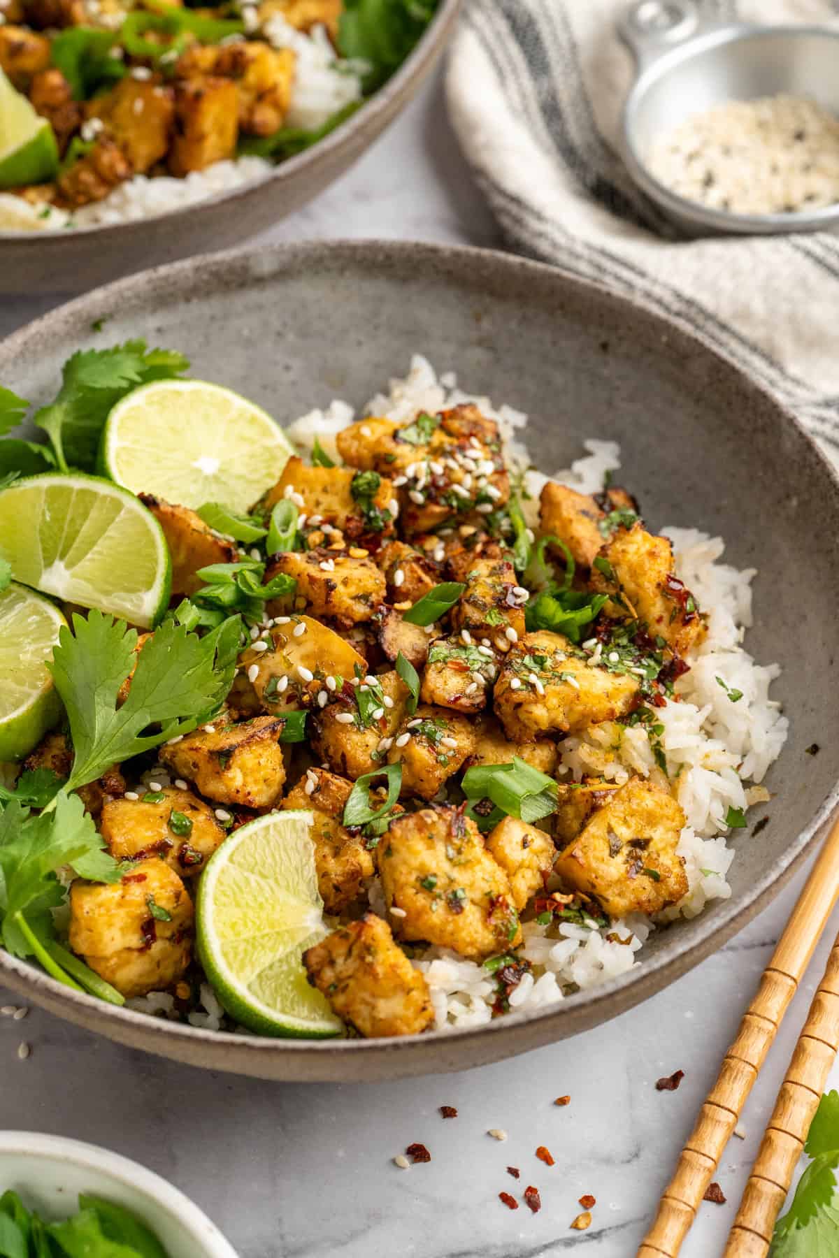 Bursting with zippy lime, sweet, citrusy cilantro, and a hit of garlic, this golden-brown cilantro lime marinated tofu is perfect for tacos. A bowl of cilantro lime marinated tofu over rice.