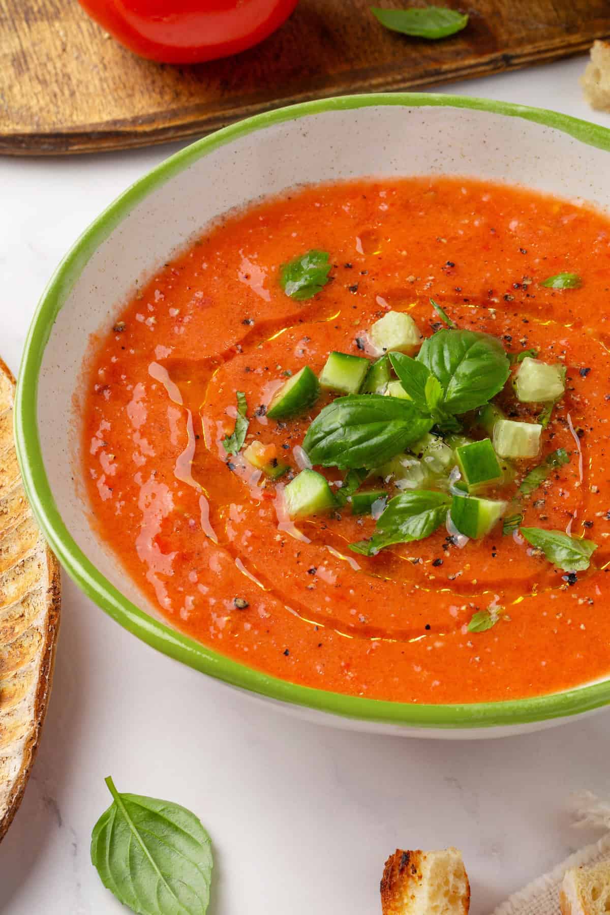 This gazpacho recipe blends farmers' market tomatoes with fresh veggies, olive oil, and vinegar for the perfect sweet 'n tangy summer soup. Chilled Spanish gazpacho in a bowl.