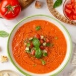Overhead image of a bowl of Spanish gazpacho with a spoon in it.