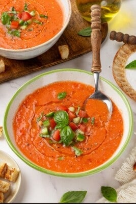 A bowl of Spanish gazpacho with a spoon in it.