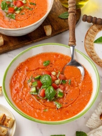 A bowl of Spanish gazpacho with a spoon in it.