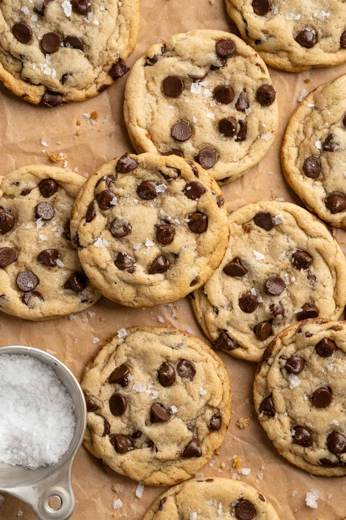 These vegan sourdough chocolate chip cookies are about to up your cookie standards. They're tender and chewy with a subtle sourdough tang. Sourdough chocolate chip cookies spread out on parchment paper.