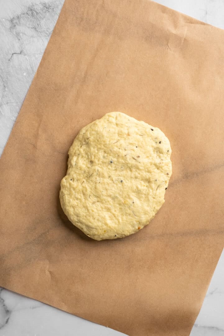 What to do with that sourdough discard? These easy sourdough discard crackers are crunchy, crispy, and flaky, with that best sourdough tang. Sourdough discard cracker dough pressed into a loose rectangle on a sheet of parchment paper.