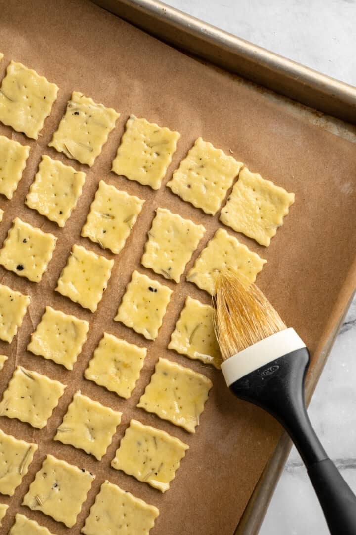 What to do with that sourdough discard? These easy sourdough discard crackers are crunchy, crispy, and flaky, with that best sourdough tang. Brushing unbaked sourdough discard crackers with olive oil.