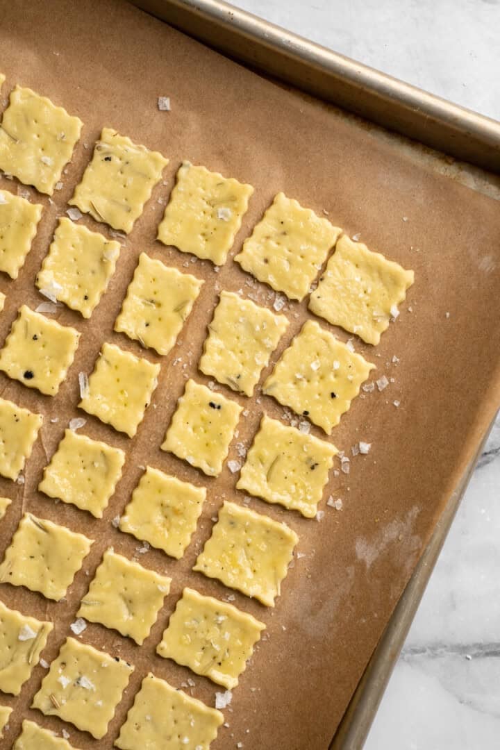What to do with that sourdough discard? These easy sourdough discard crackers are crunchy, crispy, and flaky, with that best sourdough tang. Sprinkling unbaked sourdough discard crackers with olive oil.
