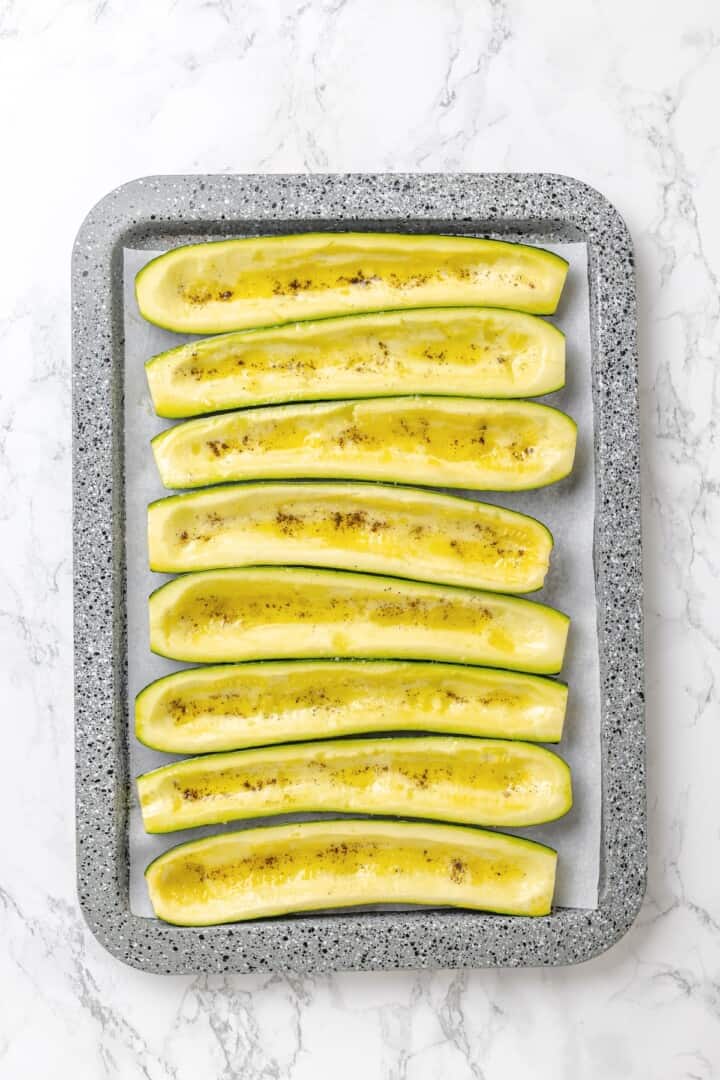 These stuffed zucchini boats are loaded with rich marinara sauce, melty vegan mozzarella, and protein-packed lentils. The perfect summer side. Seasoned zucchini boats ready to be stuffed.