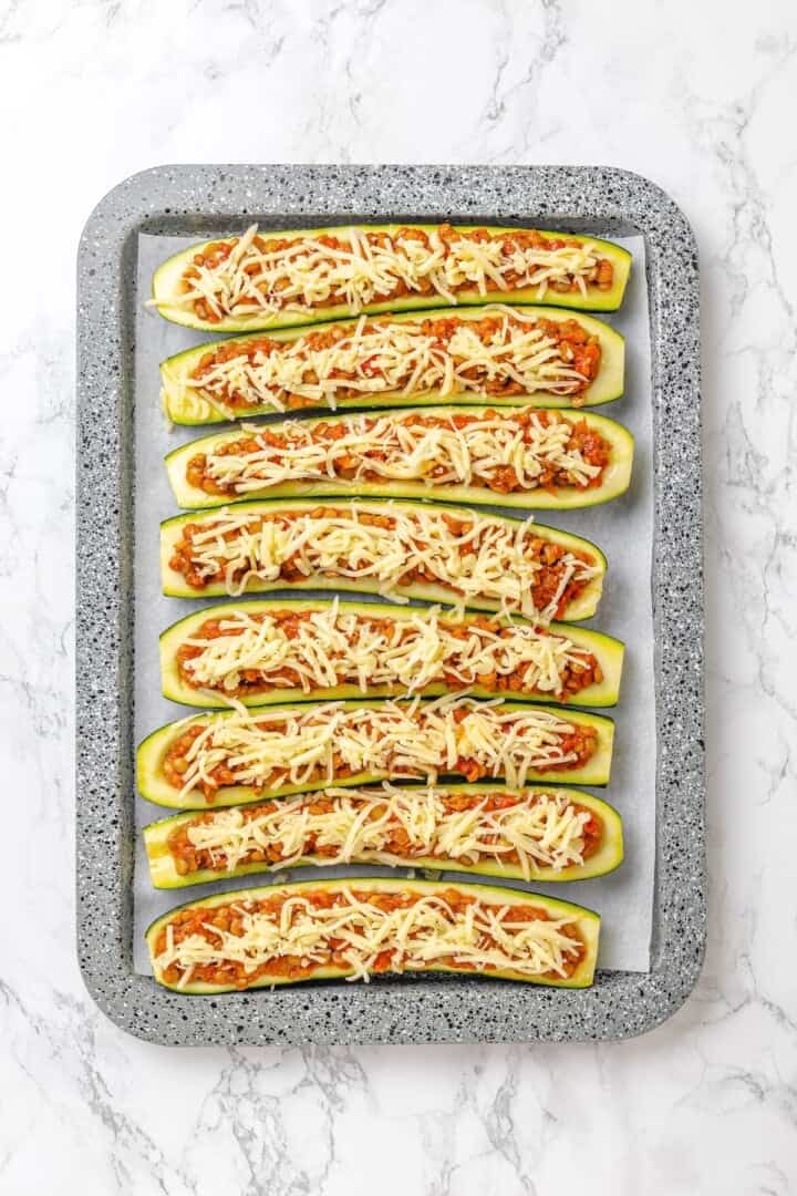 These stuffed zucchini boats are loaded with rich marinara sauce, melty vegan mozzarella, and protein-packed lentils. The perfect summer side. Zucchini boats stuffed with a lentil filling and topped with vegan mozzarella.