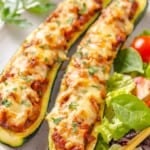 Two lentil-stuffed zucchini boats on a plate.