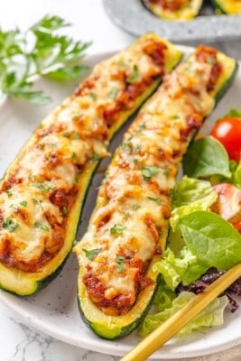 Two lentil-stuffed zucchini boats on a plate.