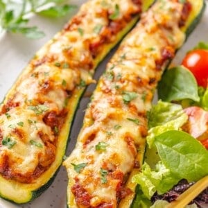Two lentil-stuffed zucchini boats on a plate.