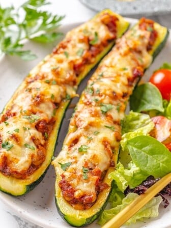 Two lentil-stuffed zucchini boats on a plate.