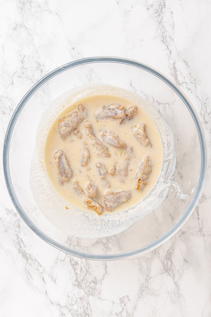 Vegan popcorn chicken features tender soy curls in a crunchy KFC-style breading served with a maple Dijon sauce. It beats takeout any day! Soaking soy curls in vegan buttermilk.