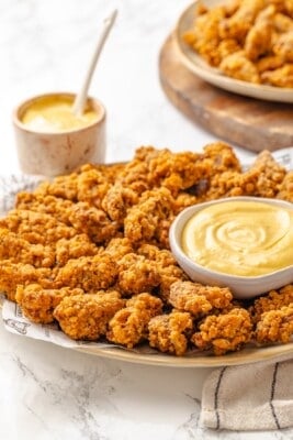 A platter with maple dijon sauce and vegan popcorn chicken.