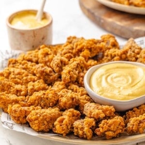 A platter with maple dijon sauce and vegan popcorn chicken.