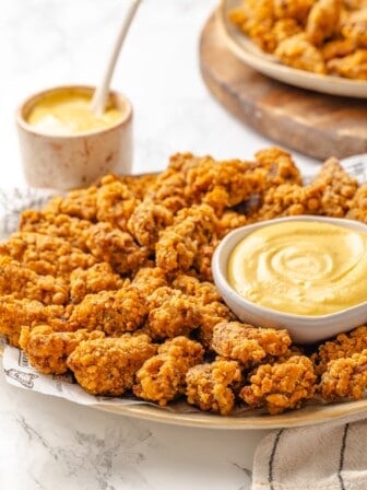 A platter with maple dijon sauce and vegan popcorn chicken.