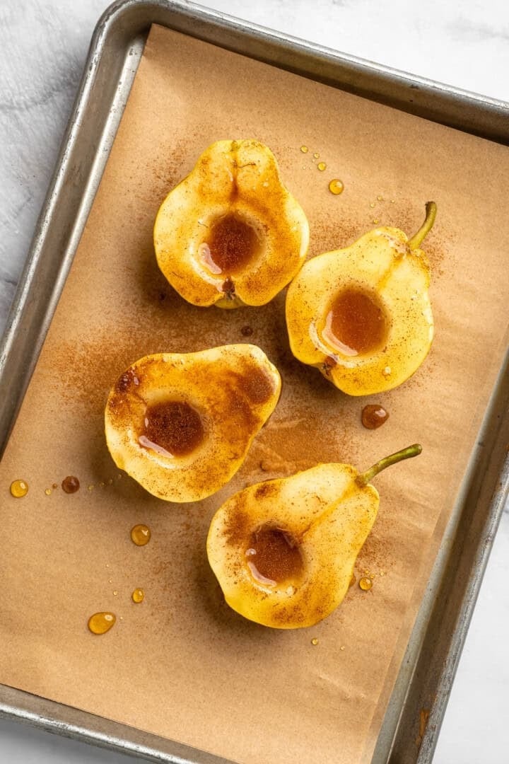 These easy, tender cinnamon baked pears are perfectly caramelized in a glossy sauce of maple syrup, cinnamon, and their own sweet juices. 4 pear halves sprinkled with cinnamon and drizzled with maples syrup.