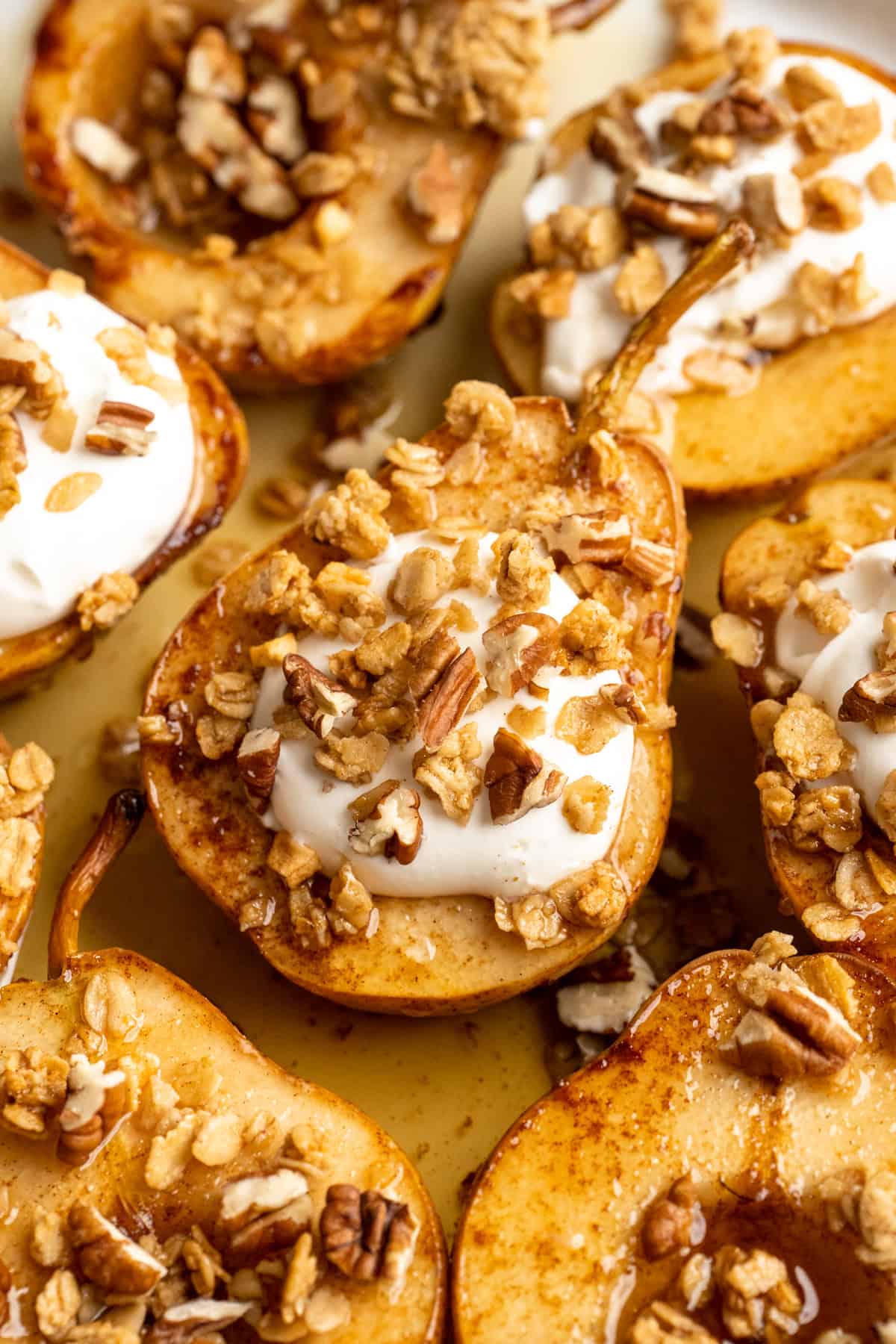 These easy, tender cinnamon baked pears are perfectly caramelized in a glossy sauce of maple syrup, cinnamon, and their own sweet juices. Cinnamon baked pears topped with coconut cream and pumpkin granola.