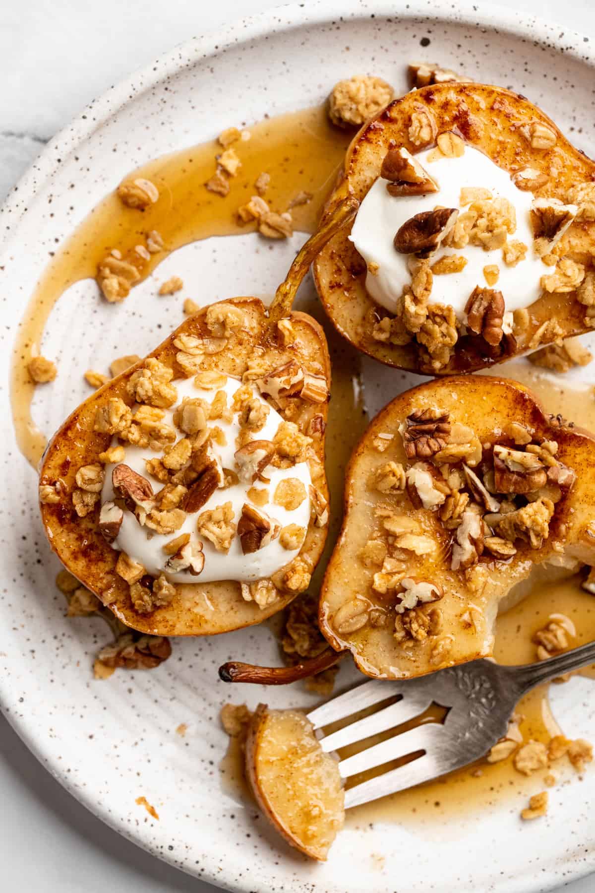 These easy, tender cinnamon baked pears are perfectly caramelized in a glossy sauce of maple syrup, cinnamon, and their own sweet juices. Cinnamon baked pears topped with coconut cream and granola.