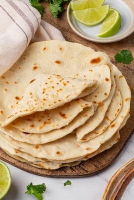 A stack of vegan flour tortillas with several folded on top.