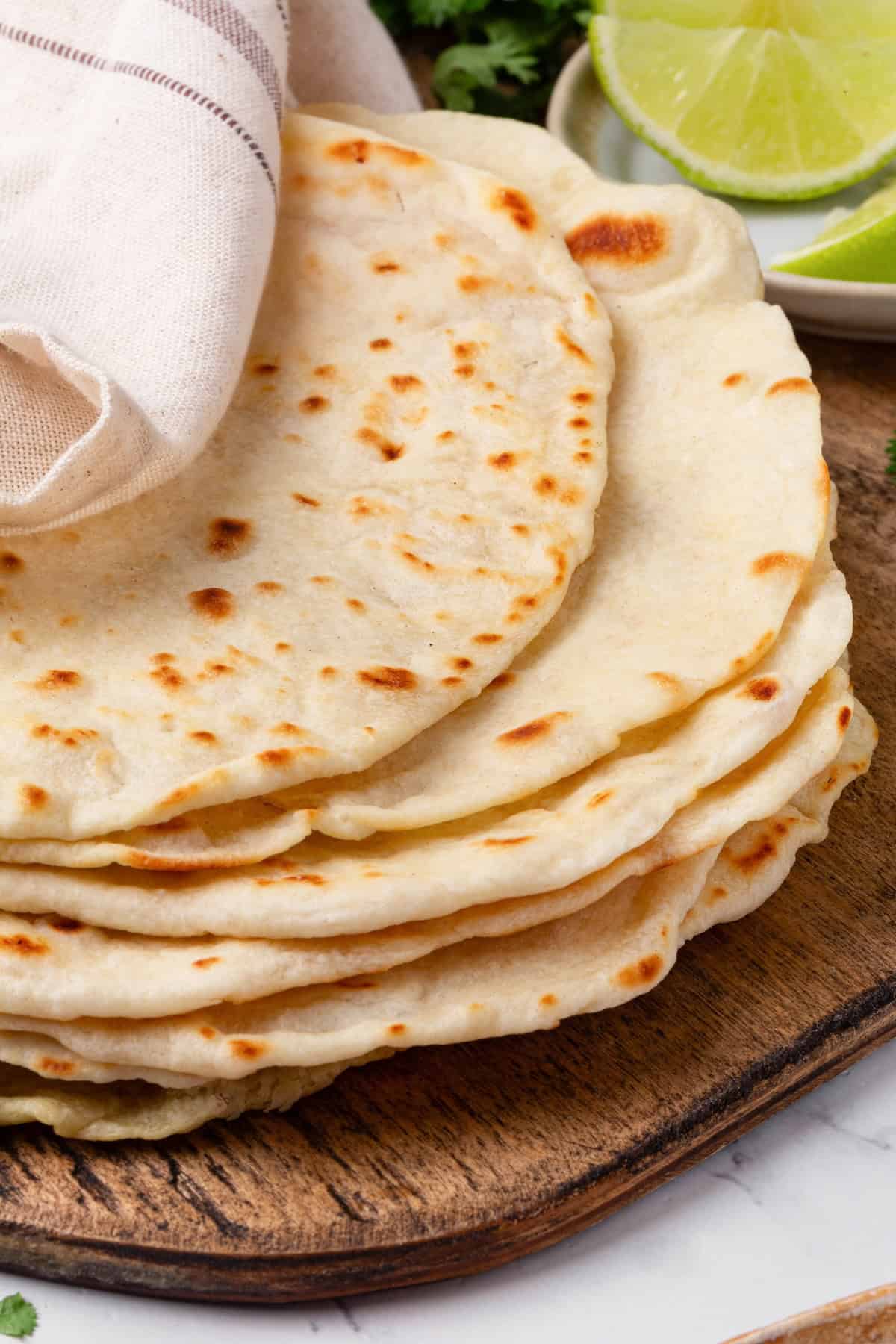 Perfectly soft and chewy, these homemade vegan flour tortillas puff up beautifully in the pan and are ideal for your next burrito. Close-up of a stack of homemade vegan flour tortillas.