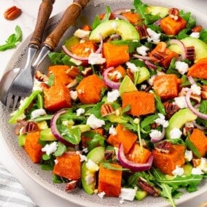 A plate full of roasted sweet potato arugula salad.