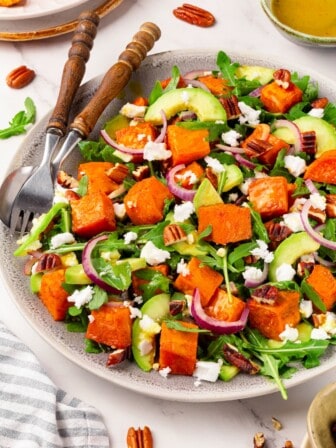 A plate full of roasted sweet potato arugula salad.