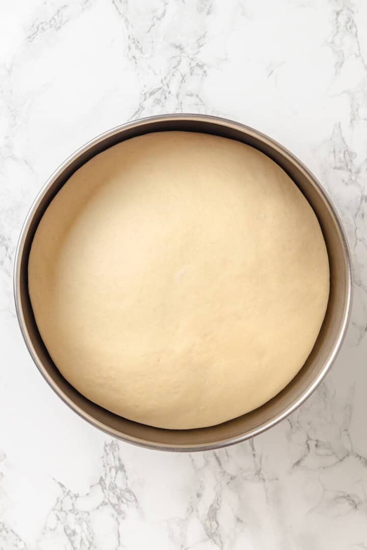 Fabulously fluffy, filled with soft, cinnamony apples, and topped with cream cheese frosting, you need these apple cinnamon rolls now. Fully risen cinnamon roll dough in a bowl.