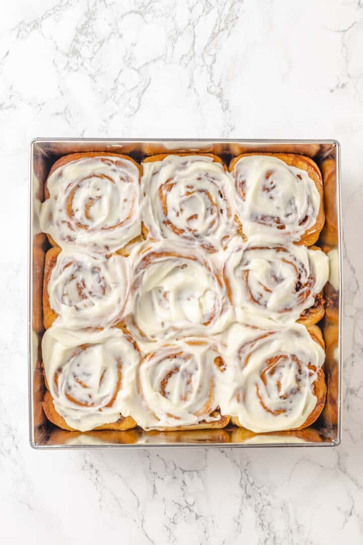Fabulously fluffy, filled with soft, cinnamony apples, and topped with cream cheese frosting, you need these apple cinnamon rolls now. Vegan apple cinnamon rolls frosted with vegan cream cheese frosting in the pan.