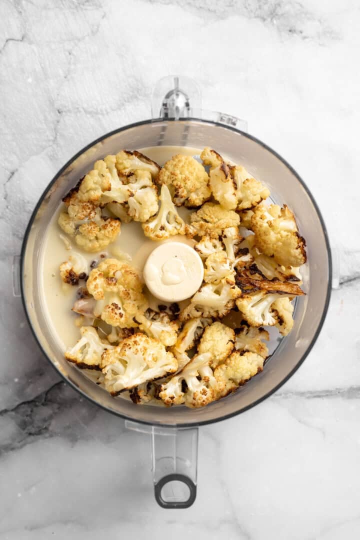 This cauliflower mash is made with roasted cauliflower and garlic for the ultimate sauvoury flavour, and coconut milk for a silky finish. Hot roasted cauliflower, garlic, salt, and melted vegan butter and coconut milk in a food processor.
