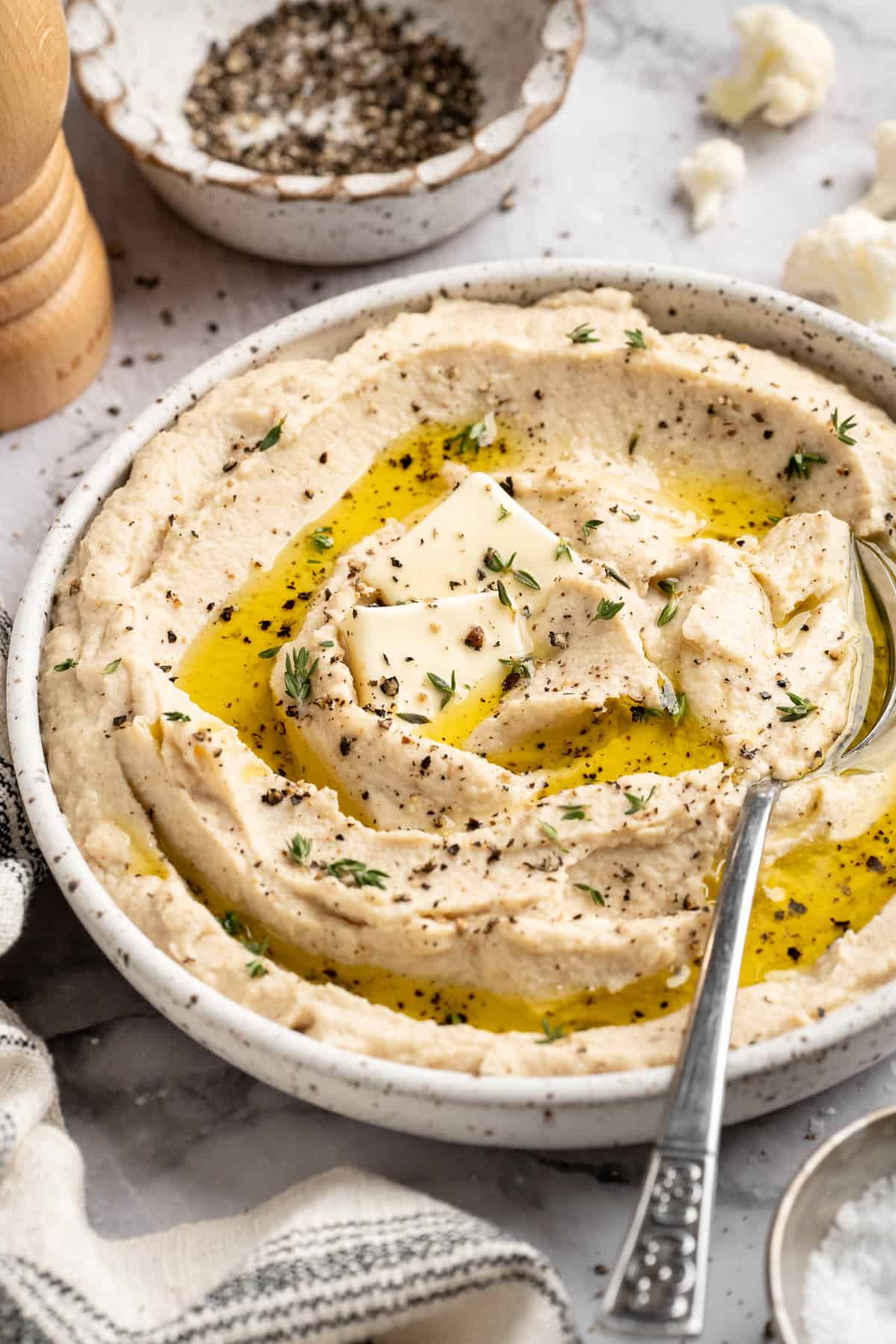 This cauliflower mash is made with roasted cauliflower and garlic for the ultimate sauvoury flavour, and coconut milk for a silky finish. A bowl of creamy vegan mashed cauliflower topped with olive oil.