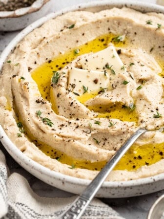 A bowl of vegan mashed cauliflower topped with olive oil.