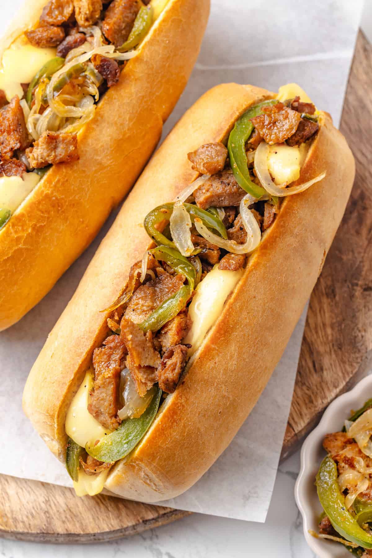 This vegan Philly cheesesteak is piled high with golden-brown, savoury soy curl "steak", tender sautéed veggies, and melted vegan provolone. Overhead image of a soy curl Philly cheesesteak sandwich.