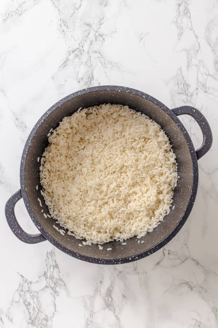 This easy yellow rice is toasted with peppery turmeric and warming cumin and simmered to fluffy perfection in veggie broth. Toasting rice in a saucepan.