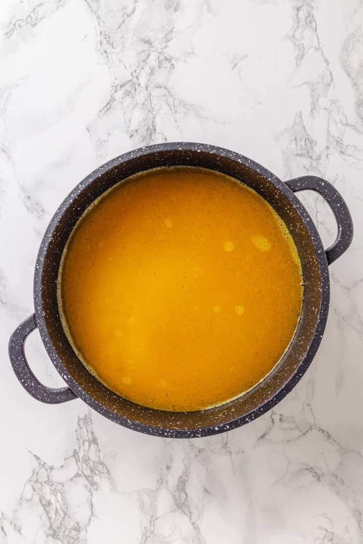 This easy yellow rice is toasted with peppery turmeric and warming cumin and simmered to fluffy perfection in veggie broth. Adding broth to a saucepan loaded with toasted rice and spices.