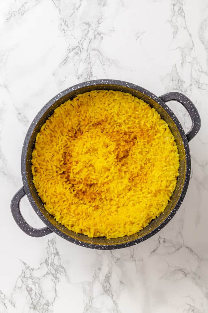 This easy yellow rice is toasted with peppery turmeric and warming cumin and simmered to fluffy perfection in veggie broth. Perfectly cooked yellow rice just before fluffing.